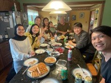 Center director and students sharing a meal at home